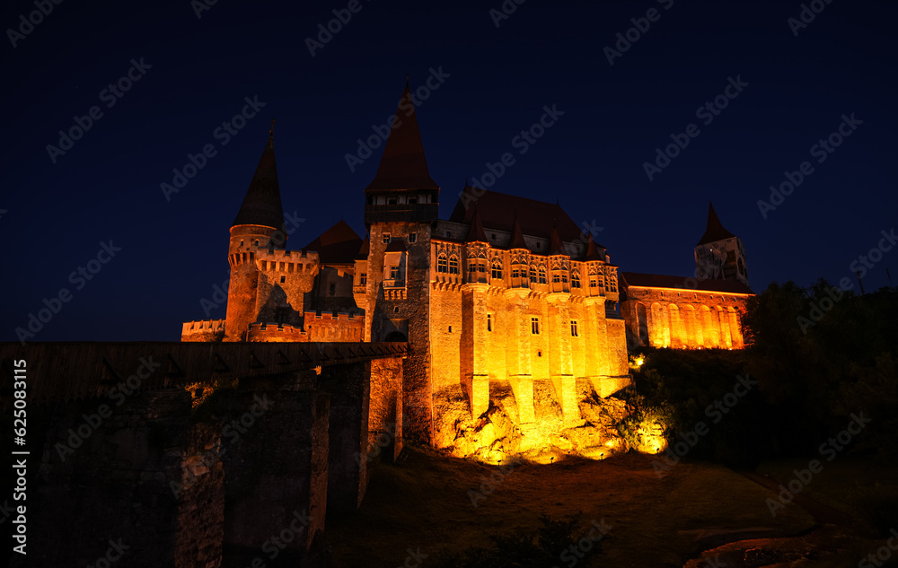 Corvin (Hunyad) Castle in Hunedoara during the evening. Wide angle night phoot with this amazing medieval castle landmark in Romania. Corvin (Hunyad) Castle in Hunedoara during the evening. Wide angle night phoot with this amazing medieval castle landmark in Romania.