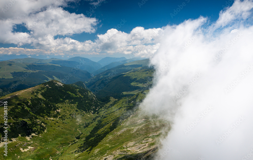 Beautiful roads of Romania. Aerial photo with Transalpina road on top of the mountains with big clouds above. Curved waving road. Beautiful roads of Romania. Aerial photo with Transalpina road on top of the mountains with big clouds above. Curved waving road.