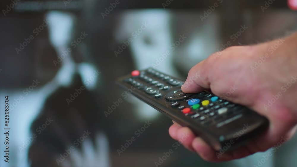 the man presses the buttons of the remote control the man presses the buttons of the remote control
