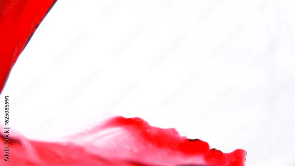 Hibiscus tea pours into a glass forming a beautiful wave Hibiscus tea pours into a glass forming a beautiful wave