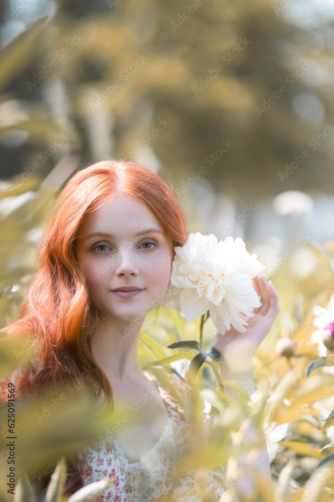 Elegant portrait of a tender girl with a white peony in a summer garden Elegant portrait of a tender girl with a white peony in a summer garden