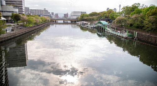 Small pier on big river in city.