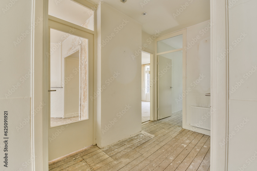 an empty room with wood flooring and white paint on the walls, there is a large mirror in the corner