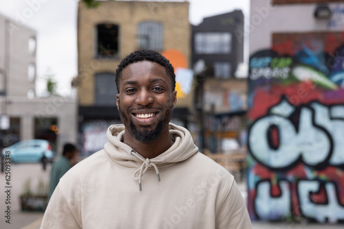 Portrait of young adult black male student on city street photo