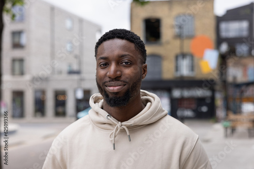 Portrait of young adult black male student on city street