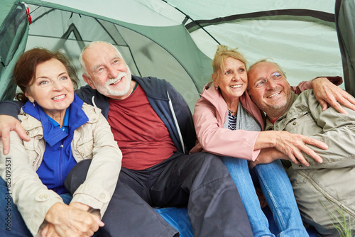 Senior couples looking away while sitting in tent