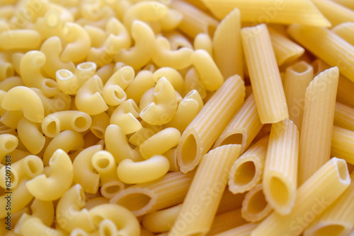 Uncooked Elbow pasta and Penne pasta background. Italian food. 