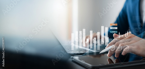 business finance and investment with a captivating data analysis concept, businessman using laptop and tablet to analyze market data, plan strategies, and conduct market research. photo