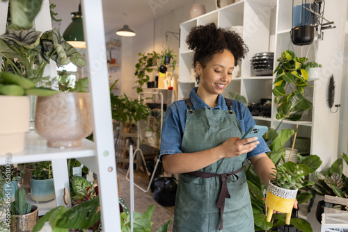 Plant shop owner taking photo of plant to sell online 