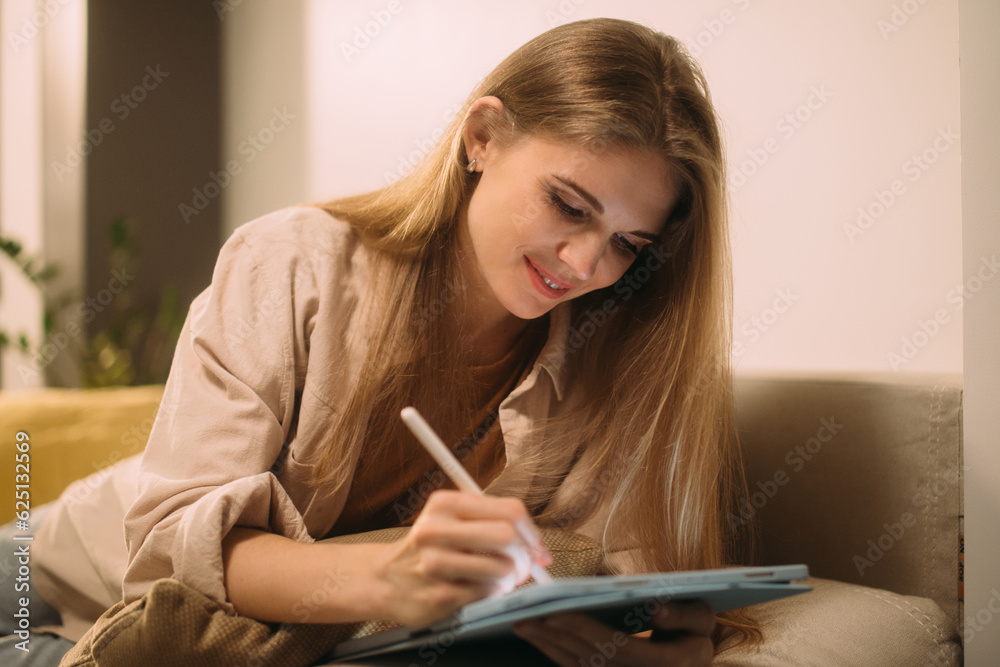 Smiling blonde woman working on the sofa Smiling blonde woman working on the sofa