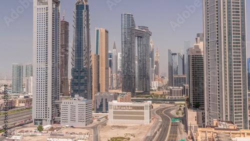 Many towers and skyscrapers with traffic on streets in Dubai Downtown and financial district all day timelapse.