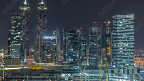 Cityscape with skyscrapers of Dubai Business Bay and water canal aerial night timelapse.