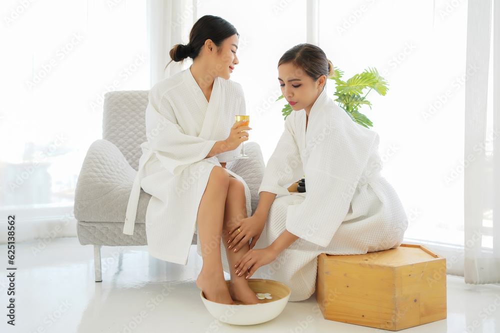Group women friends relaxing enjoy and spa foot massage put on bathrobe in modern room. Spa beauty massage healthy wellness. Spa Thai therapy treatment aromatherapy for body woman Group women friends relaxing enjoy and spa foot massage put on bathrobe in modern room. Spa beauty massage healthy wellness. Spa Thai therapy treatment aromatherapy for body woman