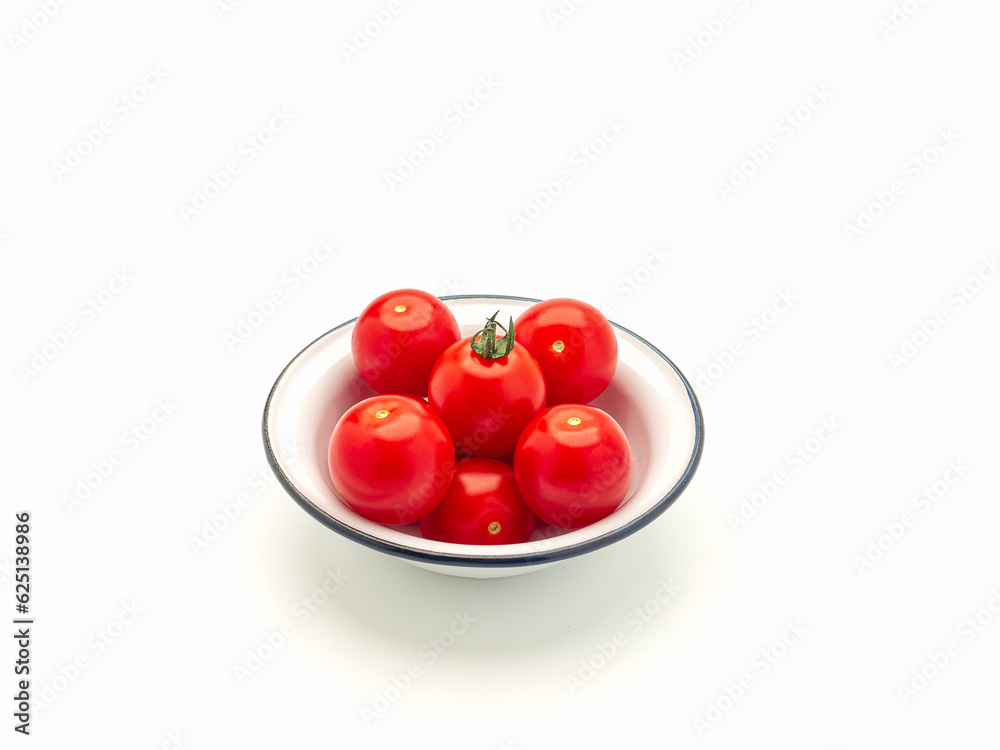 Fresh tomatoes on a white plate on a white background. Fresh tomatoes on a white plate on a white background.