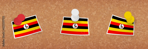 Uganda flag pinned in cork board, three versions of Uganda flag.