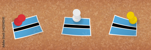 Botswana flag pinned in cork board, three versions of Botswana flag.