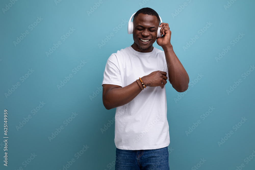 30 year old American male adult in white t-shirt enjoys listening to favorite music with headphones 30 year old American male adult in white t-shirt enjoys listening to favorite music with headphones