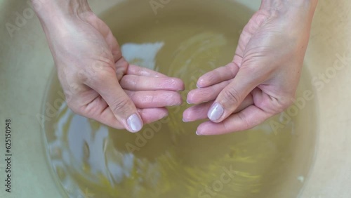 Demonstration female hands with wrinkles after bath. Woman showing her palms after long hand washing in the basin. Wrinkled or pruney skin on fingers because of soak in the water for a long time in 4K photo