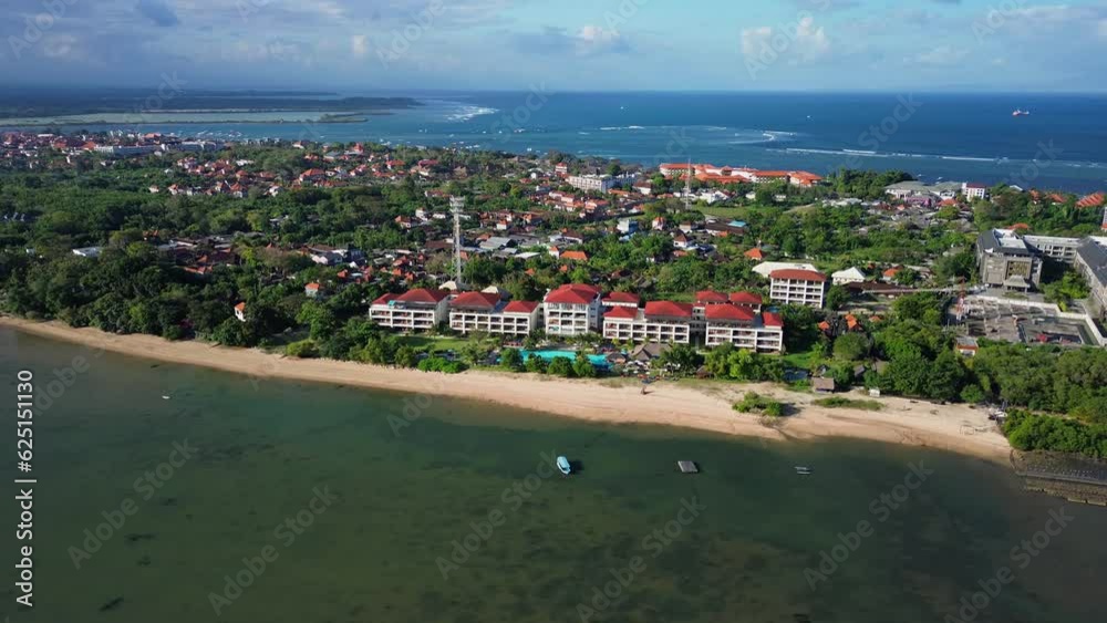 An aerial view of a picturesque island with luxurious hotels. An island in the ocean shot from a drone, a beach line and hotels along the coast. Turquoise bay in Bali and mangroves. An aerial view of a picturesque island with luxurious hotels. An island in the ocean shot from a drone, a beach line and hotels along the coast. Turquoise bay in Bali and mangroves.