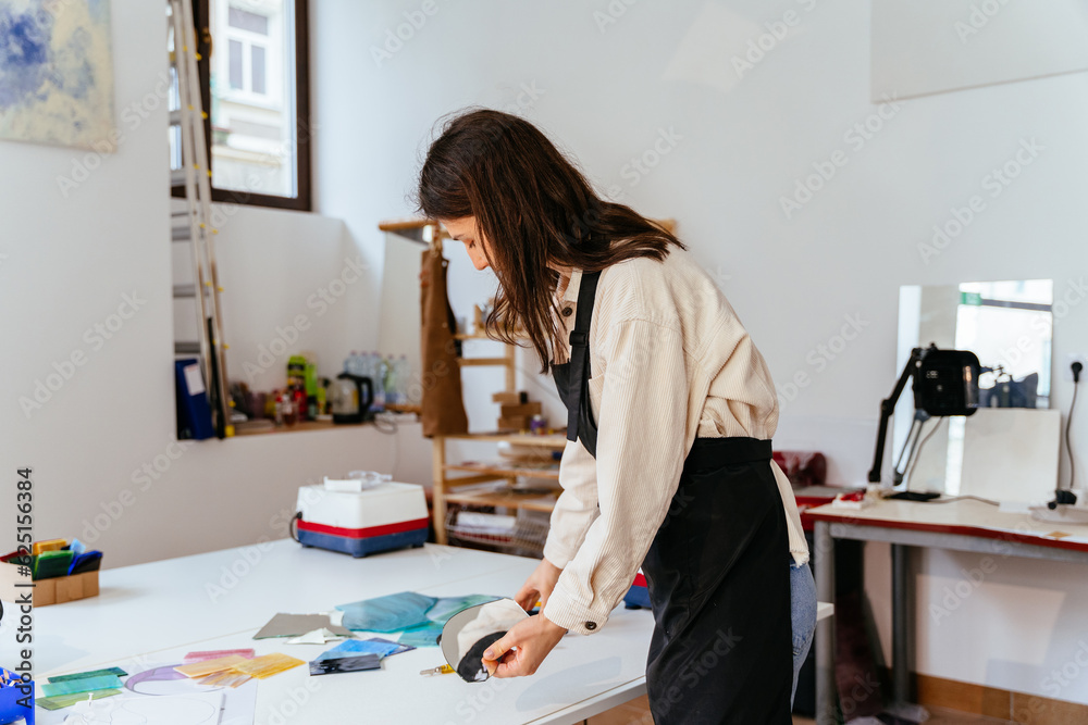 Young female stained glass artists working in studio. Stained glass art, glass work process. Art creative, handmade, Hobbies and crafts concept.