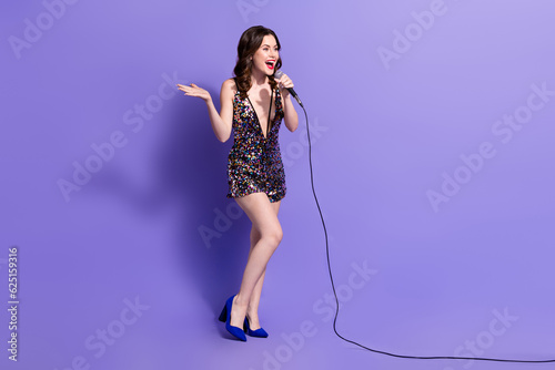 Full length photo of adorable excited woman dressed sequins overall singing songs microphone isolated violet color background