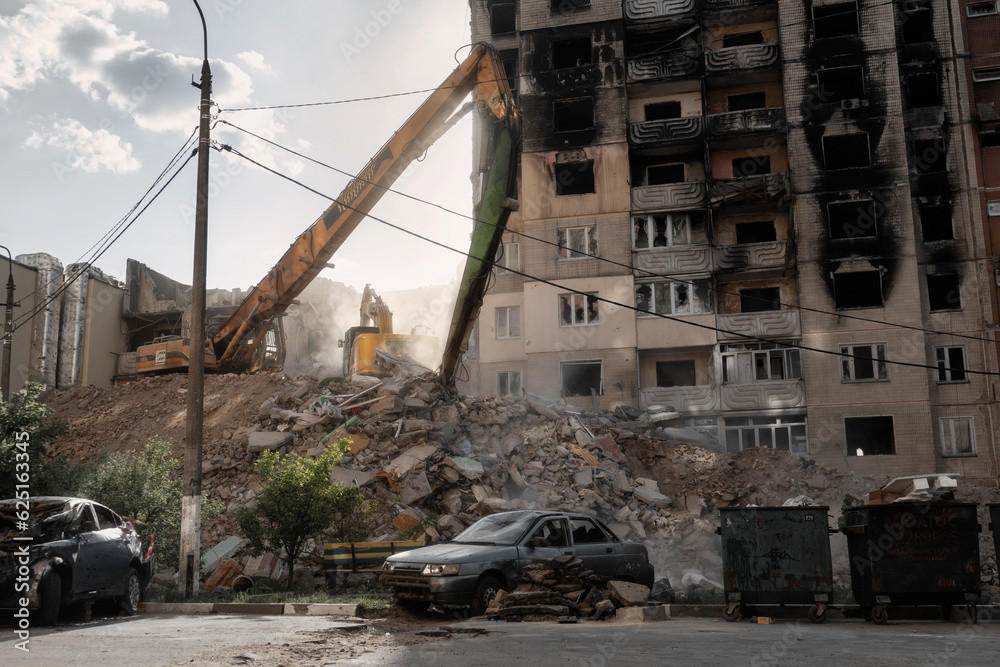 Russian invasion of Ukraine. Demolishing process of residential building. Bulldozers dismantle the rubble of a house destroyed by russian army.