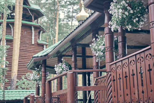 Wooden crossing on ganina pit, a bridge under the roof, decorated with flowers on a sunny summer day. Close-up of a large wooden crossing, landscaped with beautiful hanging planters.High quality photo photo