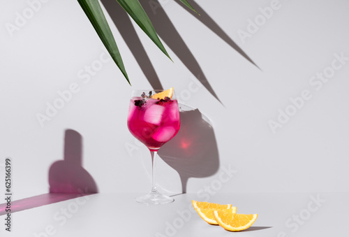 Coctel  de ginebra y tónica decorado con naranja sobre un fondo con sombras	 photo