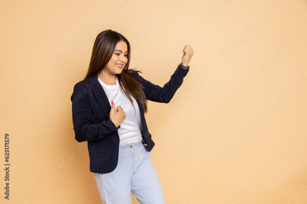 Cheerful young beautiful business woman wearing formal suit standing celebrating isolated over beige background. Copy space. Cheerful young beautiful business woman wearing formal suit standing celebrating isolated over beige background. Copy space.
