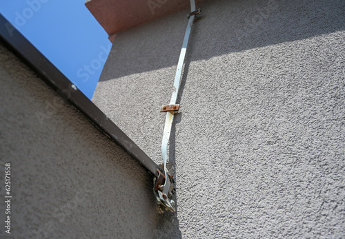 Lightning rod on the house. Wire of Lightning conductor. photo