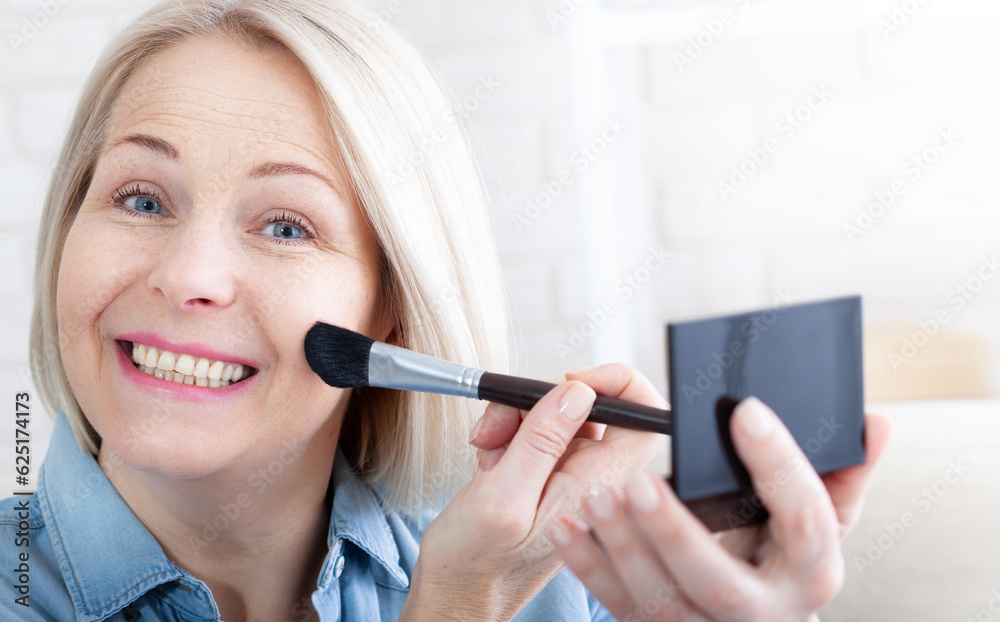 Woman is doing makeup in front of the mirror. Feminine Grace mesmerizing. A woman's delicate hands and face in profile expertly adorning her face with makeup, as she prepares for a special occasion. Woman is doing makeup in front of the mirror. Feminine Grace mesmerizing. A woman's delicate hands and face in profile expertly adorning her face with makeup, as she prepares for a special occasion.