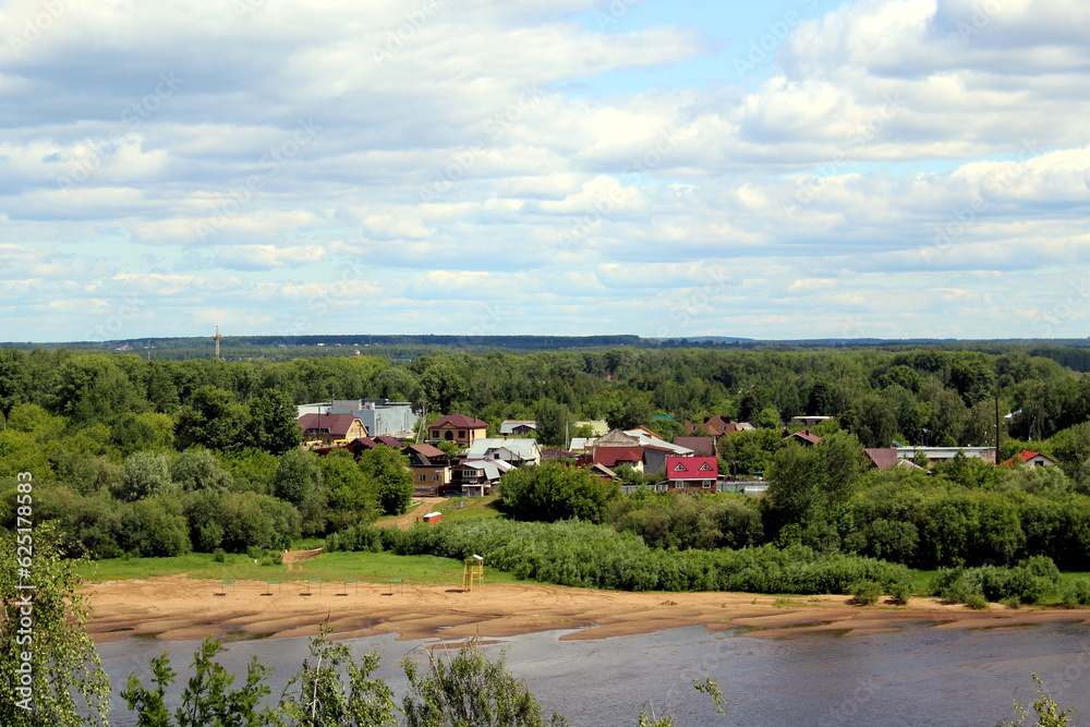 Beautiful view of the flowing river in summer with trees and fields and village houses. Beautiful view of the flowing river in summer with trees and fields and village houses.