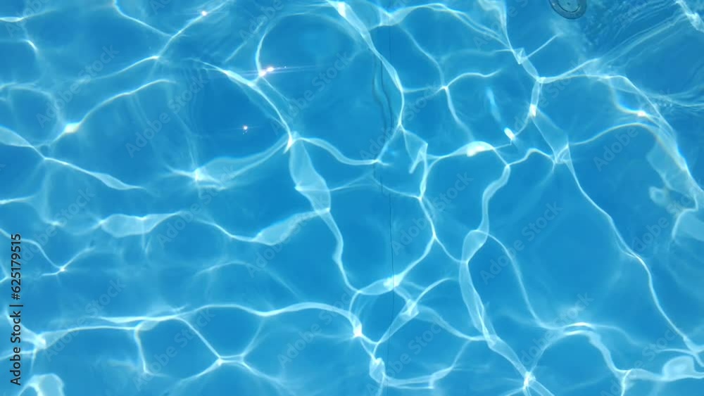 Blue water in the pool with sun glare.