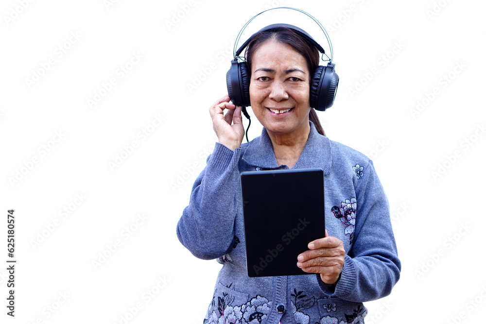Happy senior woman is watching online video clips on smart tablet, wears headphones, isolated on white background. Concept, Senior with technology media in daily life.       