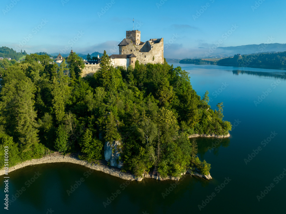 Poland. Medieval Castle in Niedzica, 14th century (upper castle), Polish or Hungarian in the Past. Artificial Czorsztyn Lake. Far view of the ruin of Czorsztyn castle, Aerial view in sunrise light