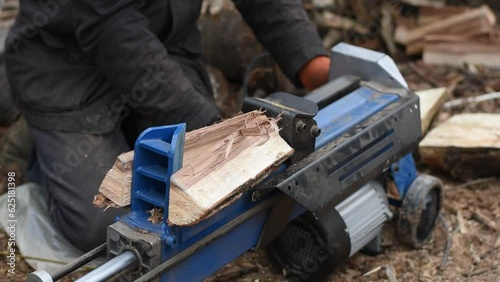 Hydraulic wood splitter splits wormwood. Preparation for the winter. photo