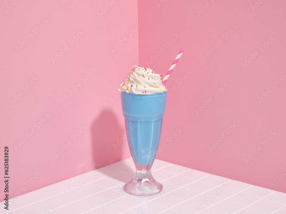 Colorful milshake with whipped cream and sprinkles on table. Cocktails and cheerful mood.