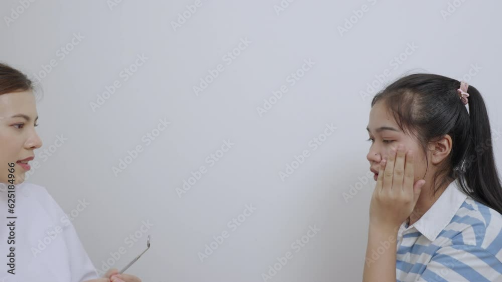 Beautiful young woman dentist in uniform using dental mirror to examine the teeth in the patient's mouth. Beautiful young woman dentist in uniform using dental mirror to examine the teeth in the patient's mouth.