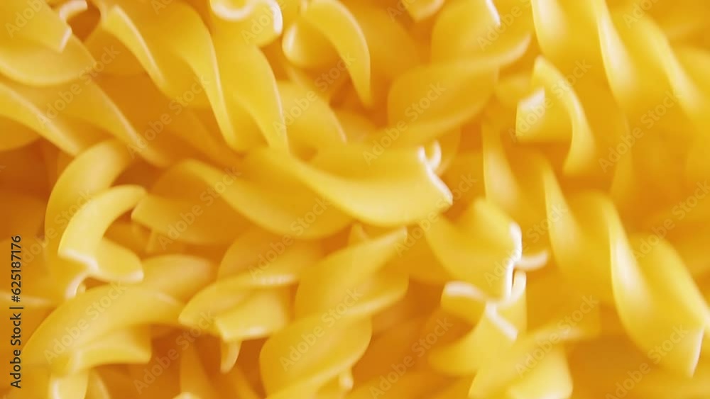 Uncooked Fusilli Pasta - Top View. Fat and Unhealthy Food. Dry Spiral Macaroni, Moving Background. Italian Culture and Cuisine. Raw Golden Pasta Pattern. Upward Movement Uncooked Fusilli Pasta - Top View. Fat and Unhealthy Food. Dry Spiral Macaroni, Moving Background. Italian Culture and Cuisine. Raw Golden Pasta Pattern. Upward Movement