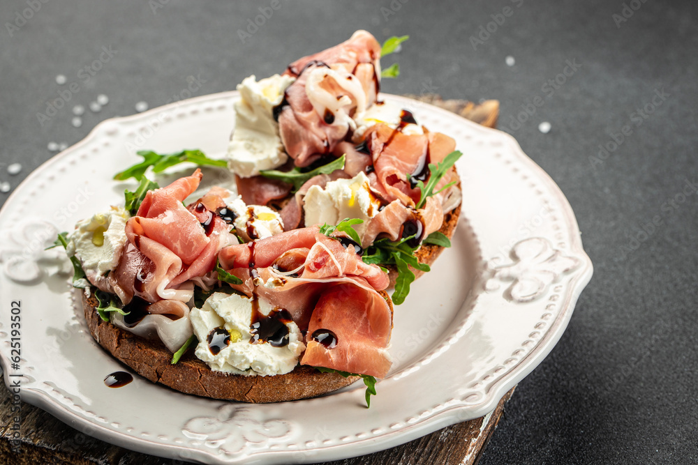 Open ham sandwiches, arugula and cream cheese. Appetizers. Food recipe background. Close up