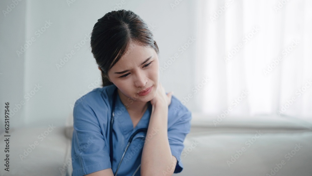 Young asian woman nurse feeling tired and depressed, suffering with neck pain after hard working. Woman doctor having neck and back pain problems. Physician burnout Young asian woman nurse feeling tired and depressed, suffering with neck pain after hard working. Woman doctor having neck and back pain problems. Physician burnout