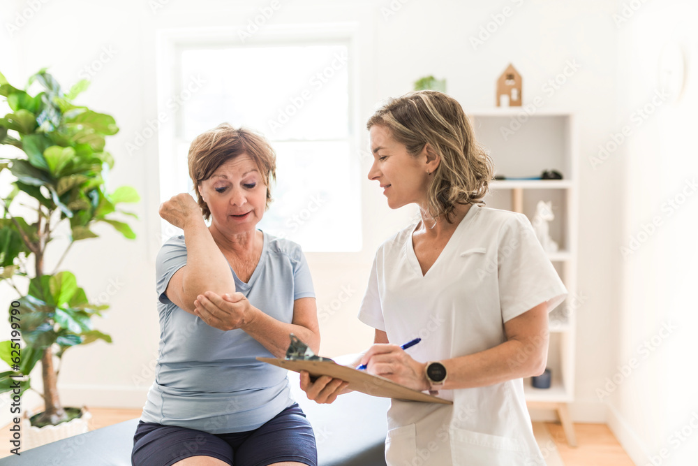 Fototapeta premium Physiotherapist working with elderly patient in clinic