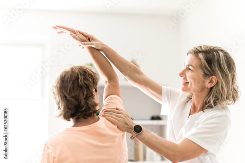 Physiotherapist working with elderly patient in clinic