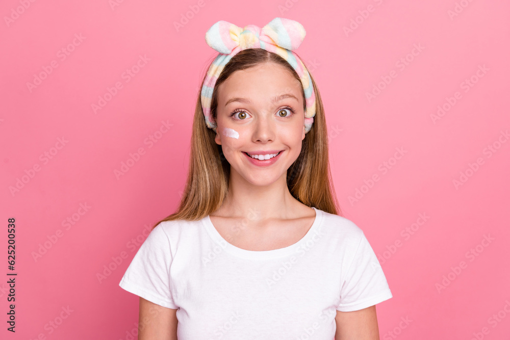 Portrait of adorable cheerful girl toothy smile peeling lotion cream face under eye isolated on pink color background Portrait of adorable cheerful girl toothy smile peeling lotion cream face under eye isolated on pink color background