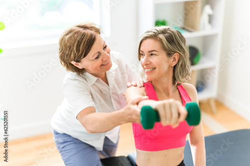 elderly Physiotherapist working with sporty patient in clinic