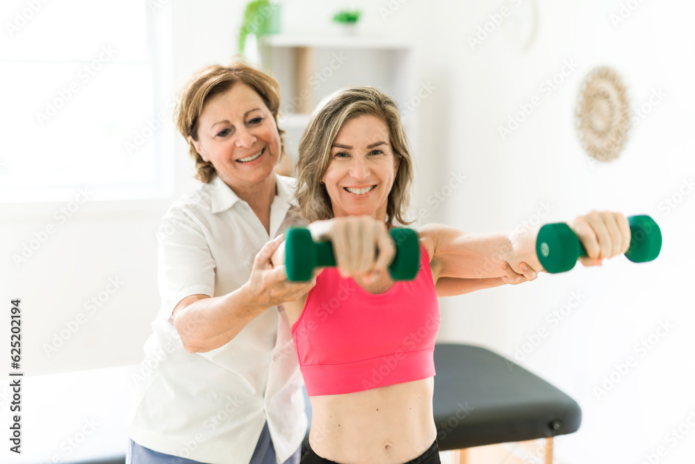 elderly Physiotherapist working with sporty patient in clinic