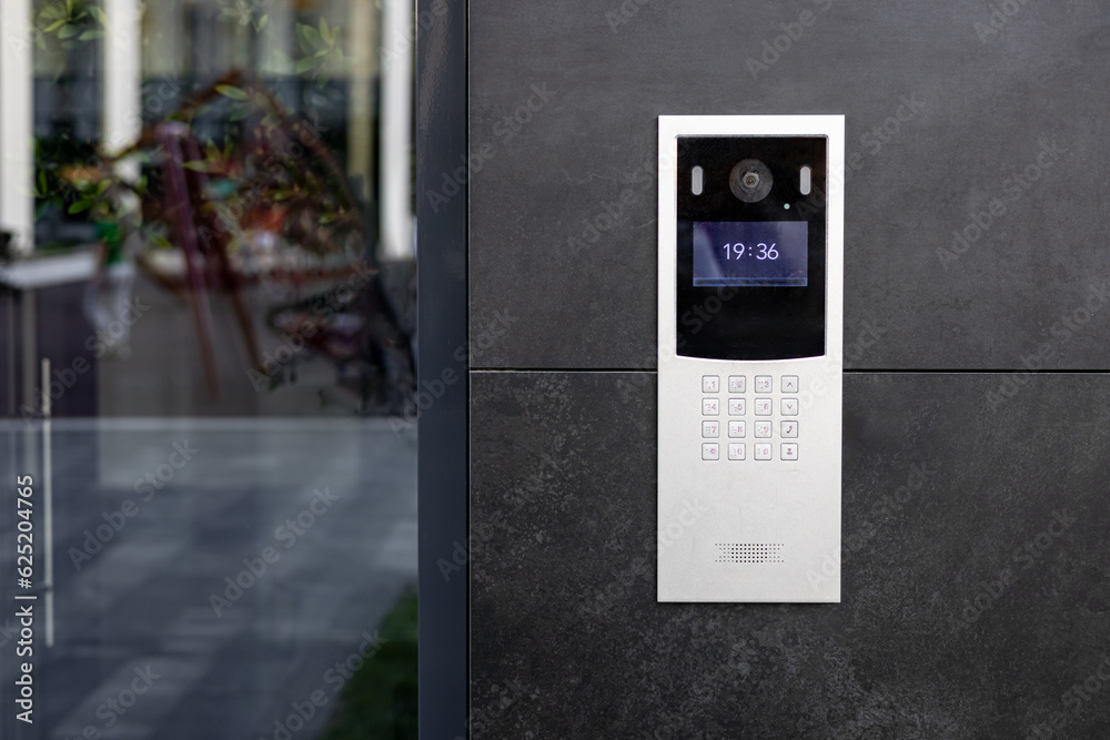 Entrance doorbell in a multi-apartment building, with a video surveillance camera, on a dark wall. Entrance doorbell in a multi-apartment building, with a video surveillance camera, on a dark wall.