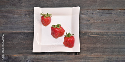 фотографія strawberries in a plate. large berries in a square plate