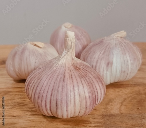3 heads of garlic are placed on a cutting board.