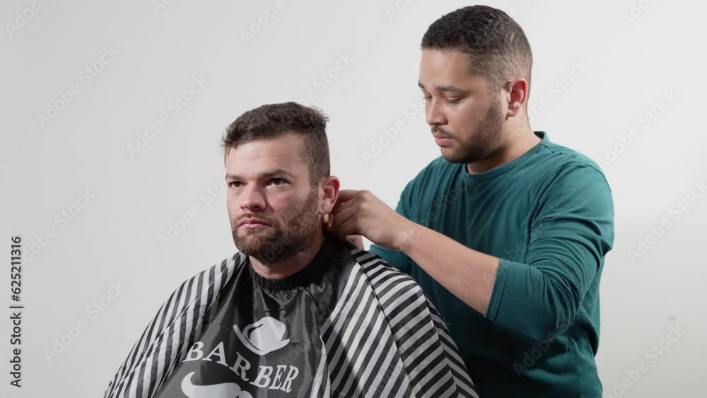 Barber at home puts and adjusts cape to client and friend - Trusted stylist - Trusted barber - Barber at home Barber at home puts and adjusts cape to client and friend - Trusted stylist - Trusted barber - Barber at home